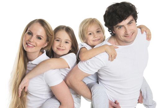 Parents giving two children piggyback rides smiling isolated on white background