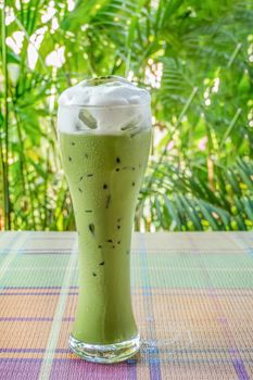 iced milk green tea on table with nature background