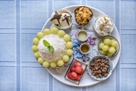 top view of Bingsu on tray served with mix  sweet topping , fruits and baked