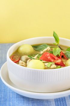 Green curry with chicken and mix vegetables in white bowl