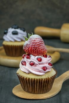 cupcake topped with fresh strawberry and whipped cream