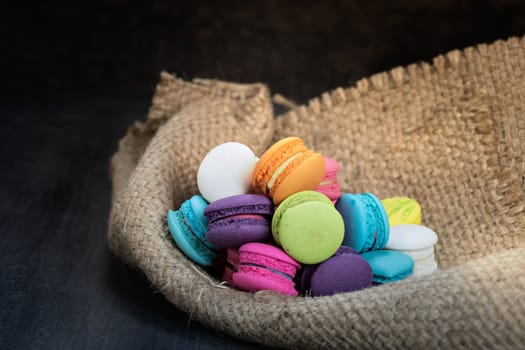 colorful of macarons on a sack over wooden table