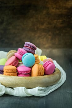 colorful of macarons on plate over wooden table