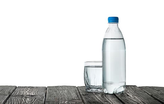 Plastic bottle and a glass with water. Wooden table. Isolated on white background.