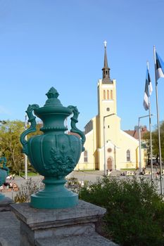 Decorative green urn in foreground on Mayeri Steps, beyond stands St John's Church in Freedom Square, Tallinn, Estonia