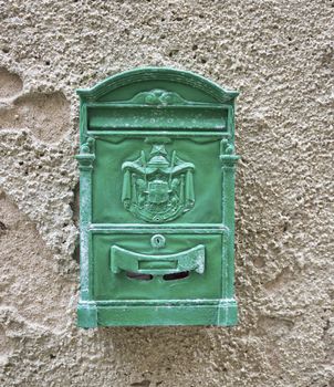 Old green Mailbox  cracked and rusting on old wall