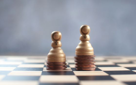 Two chess pawns with gender symbols on top of a heap of coins 