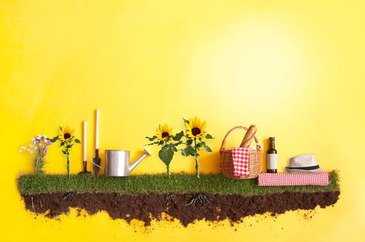 Summer picnic basket on grass patch with sunflowers