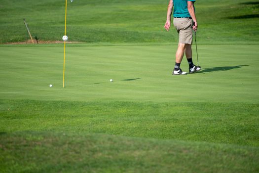 Golfer, golf player, on the green, mature male putting with several balls, not recognizable, copyspace