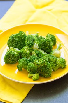 Fresh broccoli cut in yellow plate healthy natural clean food vegetable on wood background