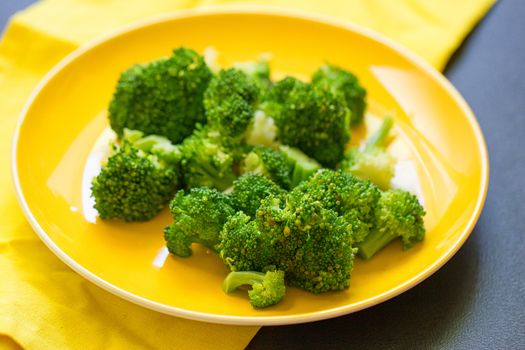 Fresh broccoli cut in yellow plate healthy natural clean food vegetable on wood background