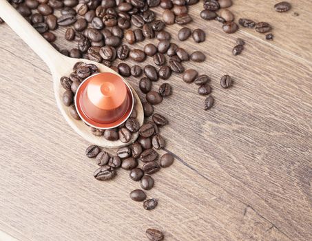 Coffee capsule and wooden spoon, pods and coffee beans on wooden background,top view.