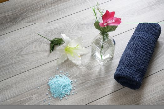 a bottle of massage oil, salts and a towel on the table