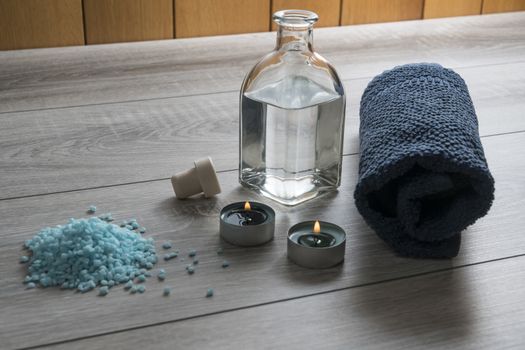 a bottle of massage oil, salts and a towel on the table