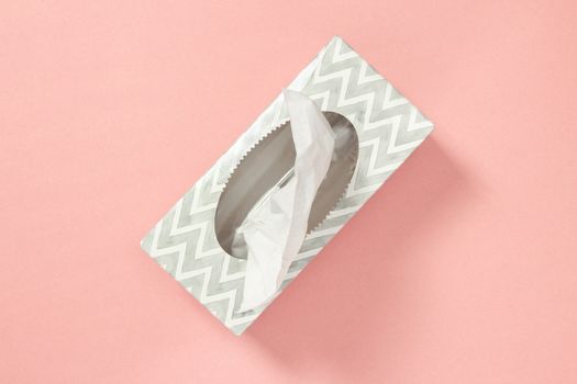 Gray tissue box on pastel pink background. Healthcare and hygiene.