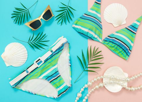Tropical vacation flat lay on turquoise and pink background. Summer fashion.