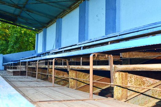 Old grandstand seats. Vintage tone. Old blue wooden grandstand stadium.