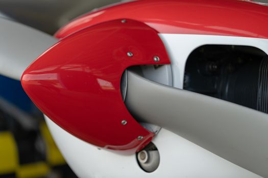 Small Sport Aircraft parked in hangar, close up. detail view of front, nose, cowling and propeller, piston aircraft