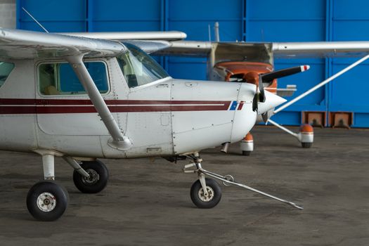 Small Sport Aircraft parked in hangar, close up. detail view of front, nose, cowling and propeller, piston aircraft