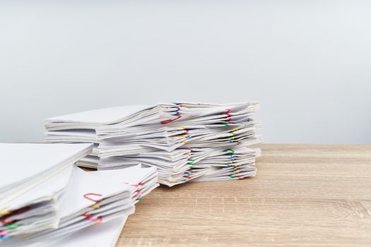 Overload paperwork report of sale and receipt with colorful paper clip on wooden table have blur document on foreground with white background and copy space. Business and finance concept success.