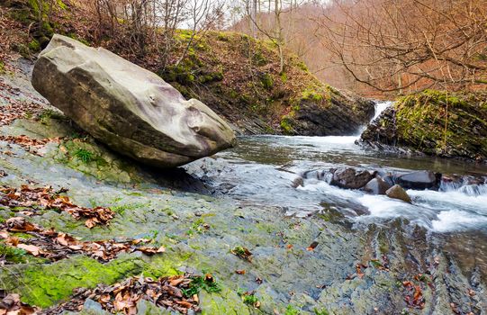 giant boulder and small cascade on the river. lovely autumn scenery of Carpathian nature. location near the village Lumshory, TransCarpathia, Ukraine