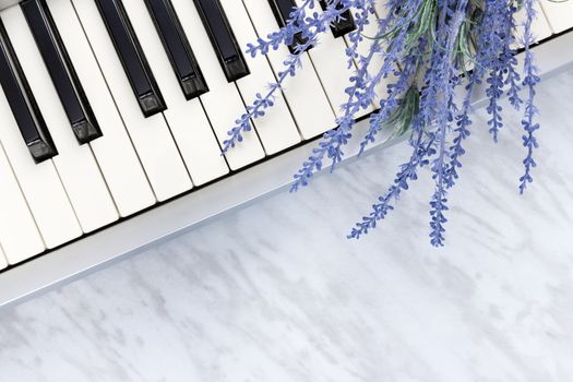Sounds of nature. Blue lavender flowers on piano keys, on marble background.