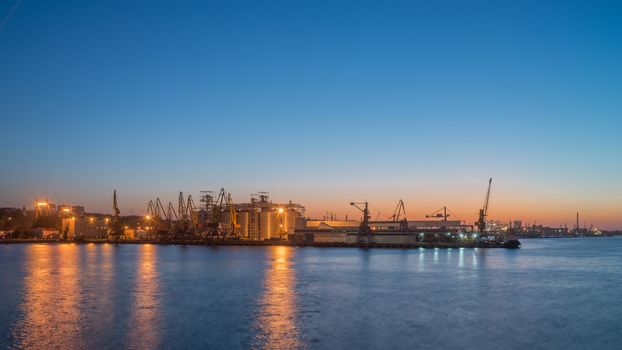 ODESSA, UKRAINE - 06.19.2018. Panoramic view of sea port and cargo terminal from the side of the sea terminal at summer sunset
