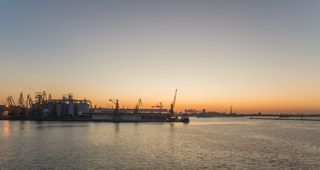 ODESSA, UKRAINE - 06.19.2018. Panoramic view of sea port and cargo terminal from the side of the sea terminal at summer sunset