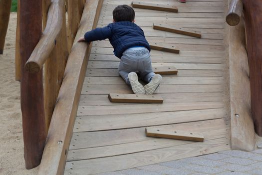 Happy young child having fun on a climbing frame outdoor