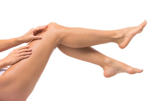 Beautiful female legs touched by hand , isolated on white