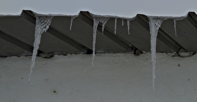 Frozen ice crystals hanging from roof top