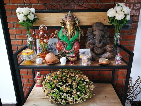 incense candles flowers cigarettes and  ceramic dolls  for Buddha statue and Thailand text were words to pray god