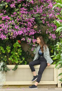 Teen girl smell  bougainvillea flowers in garden