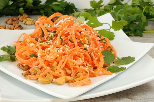 Carrot ribbon salad bathed with yoghurt dressing seasoned with fried nuts and sesame seeds, fresh coriander