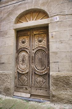 very old wooden door with texxture and artwork in sardinia