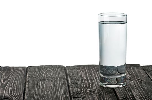 Single glass of water on wooden table isolated on white background