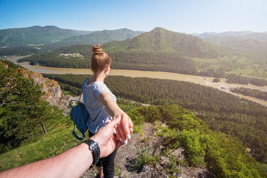 Follow me concept - Woman wanting her boyfriend to follow her in travel on the top of mountain in Altai