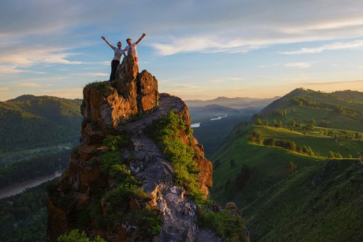 Happy man and woman on top mountain in Altai, sunset light, beauty summer landcape