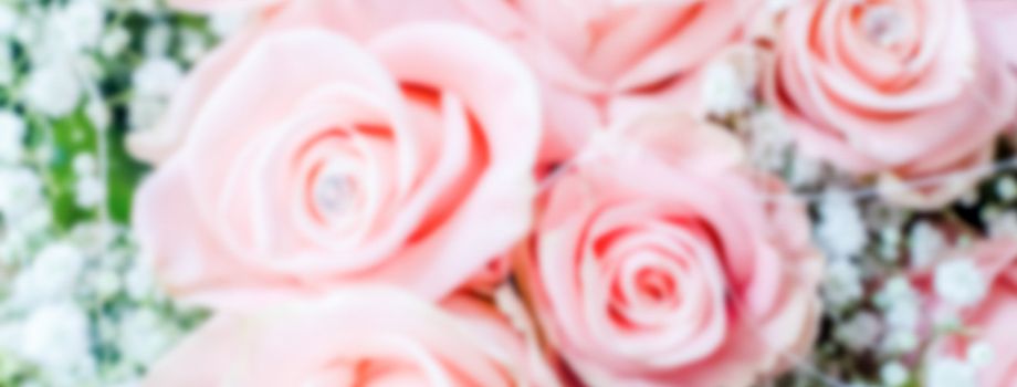 Defocused background with bouquet of pink roses. Intentionally blurred post production for bokeh effect
