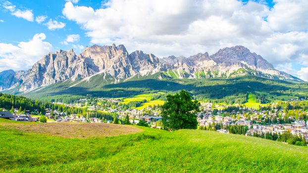 Panorama of Cortina d'Ampezzo with green meadows and alpine peaks on the background. Dolomites, Italy