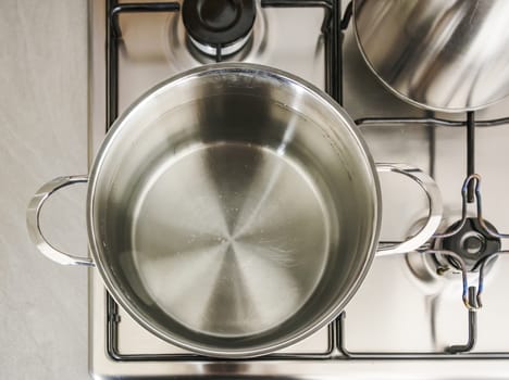 a metal pot on the stove with boiling water to cook spaghetti