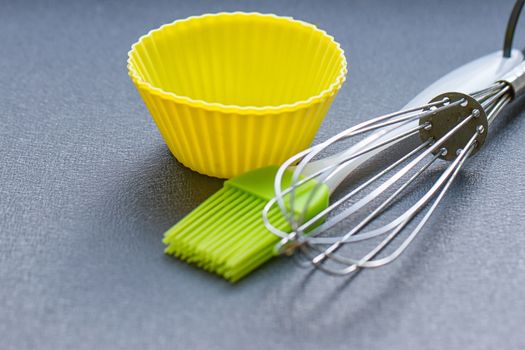 Rainbow silicone confectionery utensils on a blue background