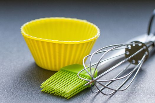 Rainbow silicone confectionery utensils on a blue background