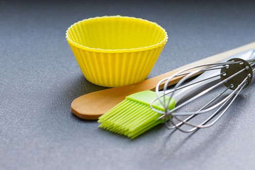Rainbow silicone confectionery utensils on a blue background