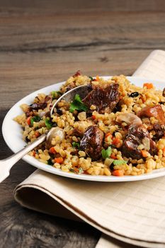 Pilaf   from bulgur with meat, vegetables and barberry