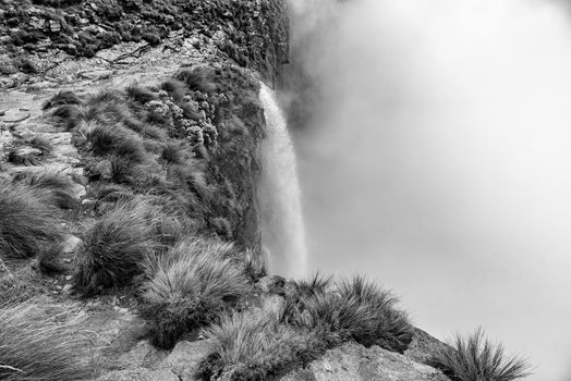 Monochrome view of the Tugela Falls, the second tallest waterfall on earth. The Tugela River plunges 948 m in five steps from the top of the Amphitheatre in the Drakensberg