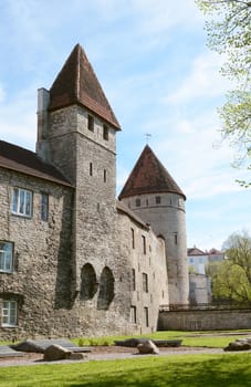 Round and square towers with tiled roofs in the medieval town wall in Tower's Square, Tallinn, Estonia