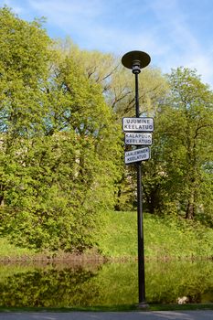 Warning signs on a lamp post by water, in Estonian - swimming prohibited, no fishing, no ice-breaking