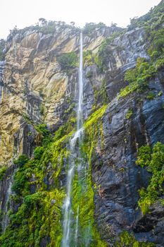 Waterfall in Milford Sound lake landscape, New Zealand