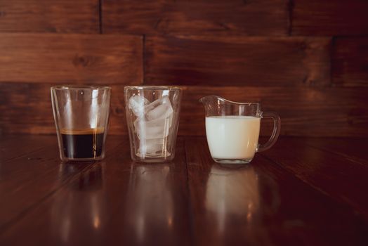 three ingredients for coffee with ice are spread out over cups.